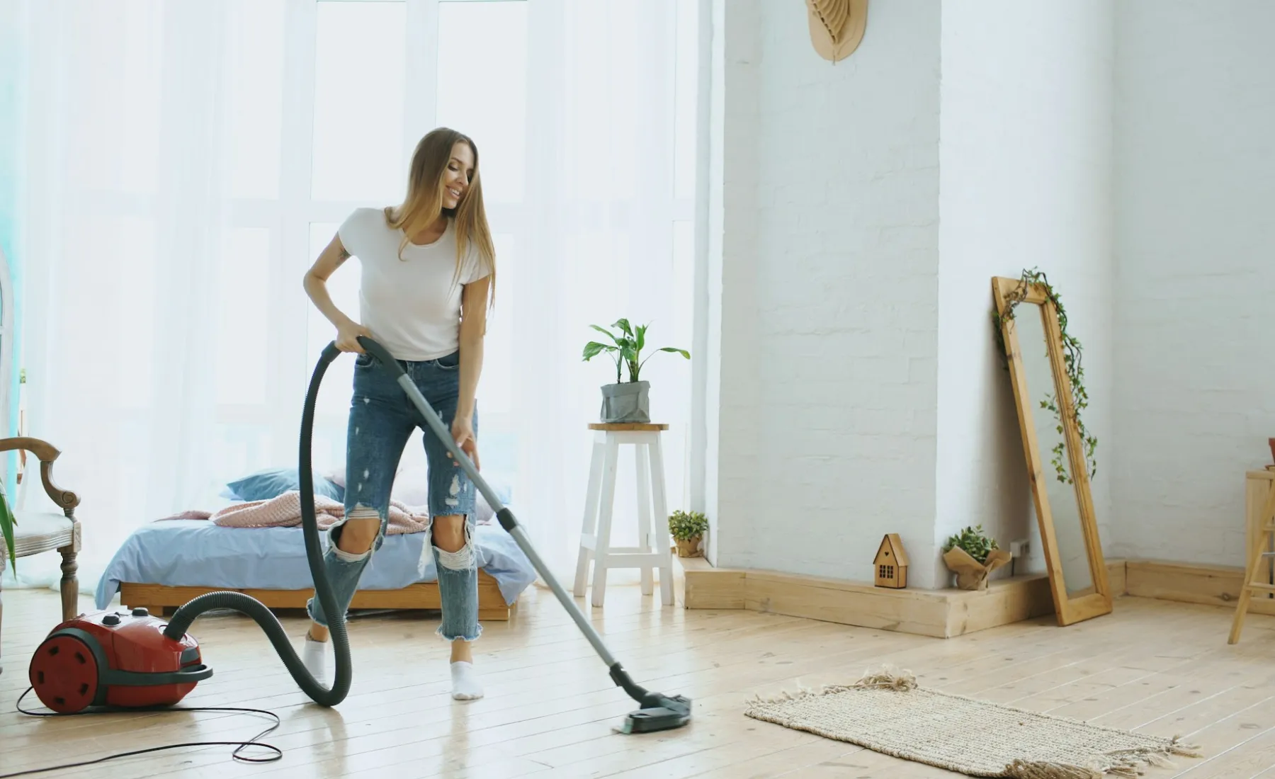 A woman vacuuming a bright living room